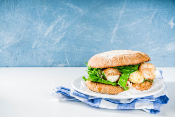 Various seafood and fish burgers assortment. Homemade healthy burger with grilled prawn, salmon, tuna, sea bass, fresh herbs, mozzarella cheese and baby spinach.