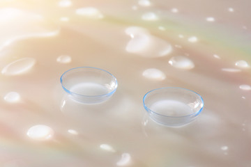 Contact lenses macro on white glass table with color reflections