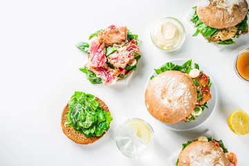 Various seafood and fish burgers assortment. Homemade healthy burger with grilled prawn, salmon, tuna, sea bass, fresh herbs, mozzarella cheese and baby spinach.