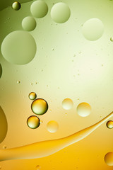 macro background from mixed water and oil in green and orange color