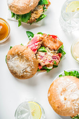 Various seafood and fish burgers assortment. Homemade healthy burger with grilled prawn, salmon, tuna, sea bass, fresh herbs, mozzarella cheese and baby spinach.