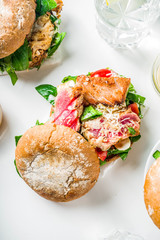 Various seafood and fish burgers assortment. Homemade healthy burger with grilled prawn, salmon, tuna, sea bass, fresh herbs, mozzarella cheese and baby spinach.
