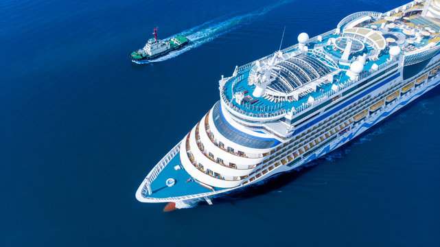 Aerial view of beautiful white cruise ship above luxury cruise running with tug boat in the ocean sea  concept tourism travel on holiday take a vacation time on summer.  forwarder mast