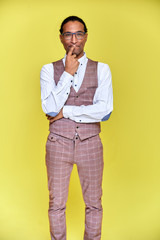 Vertical Portrait Young man with short-haired African American in a business suit on a yellow background. Standing and talking right in front of the camera.