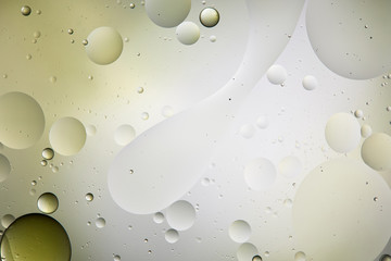 abstract texture from mixed water and oil bubbles in light green and grey color