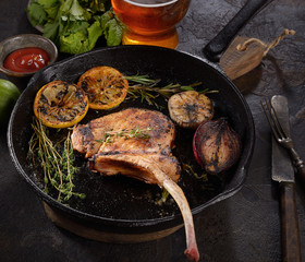 grilled pork steak tomahawk in a pan on a dark background