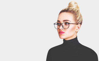 Beautiful blond woman in black turtleneck and glasses.