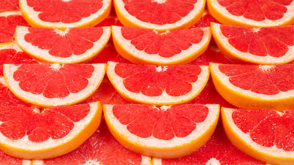 Grapefruit red juicy slices background. top view.