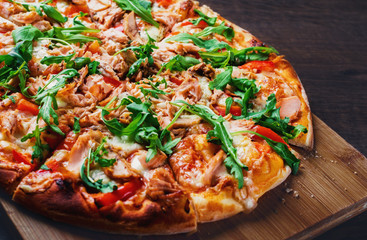 Pizza with Mozzarella cheese, salmon fish, tomato sauce, pepper. Italian pizza on wooden table background