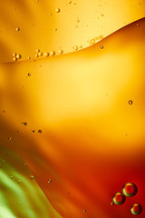 Beautiful abstract background from mixed water and oil in orange, red and green color