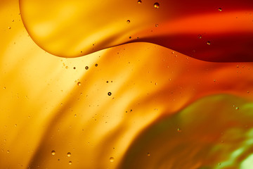 Beautiful abstract background from mixed water and oil in orange, red and green color