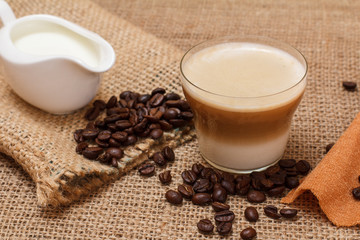 Coffee cappuccino and coffee beans on sackcloth background