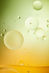 creative background from mixed water and oil in green and orange color