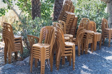 Stock of brown plastic chairs for pilgrims on nature background. Tabgha, Israel