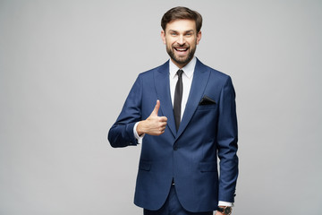 young business man going thumb up on grey background