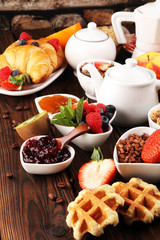 Breakfast served with coffee, orange juice, croissants, cereals and fruits. Balanced diet. Continental breakfast with granola and fruits