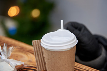 Obraz na płótnie Canvas Disposable plastic cup in paper packaging with a hot drink.