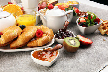 Breakfast served with coffee, orange juice, croissants, cereals and fruits. Balanced diet. Continental breakfast with granola and fruits