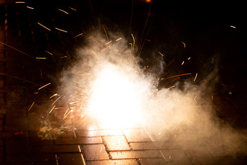 Funkensprühendes Feuerwerk einer Silvesterparty läutet das neue Jahr effektvoll ein und wünscht allen ein frohes neues Jahr mit Böllern, Knallern, Wunderkerzen und Bodenfeuerwerk mit Brandgefahr