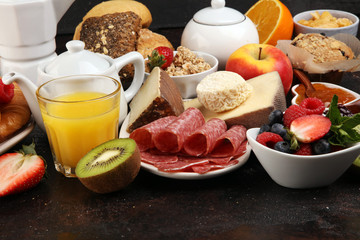 Fototapeta na wymiar Breakfast served with coffee, orange juice, croissants, cereals and fruits. Balanced diet. Continental breakfast with granola and fruits