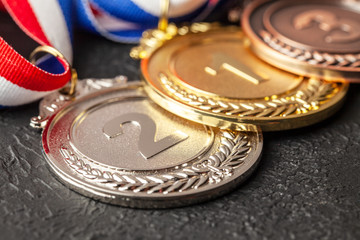 Gold, silver and bronze medal with ribbons. Award for first, second and third place in the competition. Prize to the champion. Black background