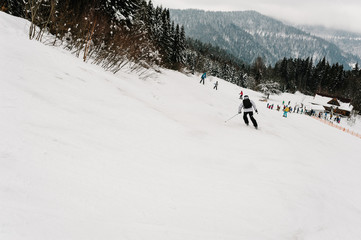 Skiing. Freeride skiing. Good skiing in the snowy mountains. Man in ski mask on skis on snow in Carpathian. On background of forest and ski slopes. Winter nature.