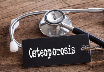 Stethoscope on wood with Osteoporosis word as medical concept