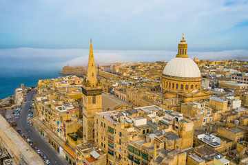Aerial landscape view of Valletta, dome, church. Clouds, fog on blue sky. Malta island