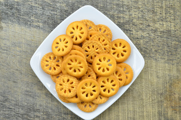 Crackers in white plate on wooden background