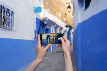 Woman holding smartphone and making street photo