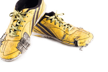 Old used  yellow worn out futsal sports shoes  on white background soccer sportware object isolated