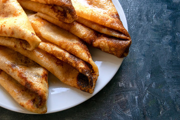 Fresh pancakes on gray background with copy space. Russian style pancakes for traditional Pancake Week. 