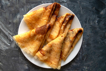 Fresh pancakes on gray background with copy space. Russian style pancakes for traditional Pancake Week. 