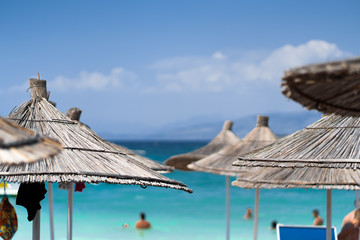 Chairs And Umbrella In Palm Beach - Tropical Holiday Banner. Beach with palm trees and sky. Summer vacation travel holiday background concept. Tropical scenery. Mountains. Post card.