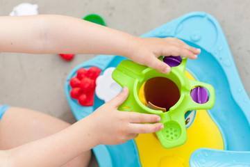 Child's hand playing with colorfull water game