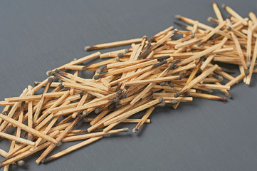 Row of many used matchsticks with burnt sulfur on dark concrete table on kitchen. Close-up