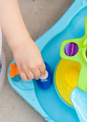 Child's hand playing with colorfull water game