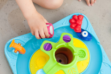 Child's hand playing with colorfull water game