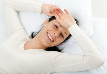 Fototapeta na wymiar Young woman lying down in bed