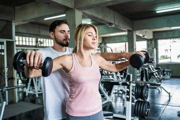 Fototapeta premium Couple of caucasian sport men women exercise partner in fitness gym