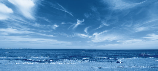 View of the sandy beach of the sea. Color of the year 2020 classic blue toned