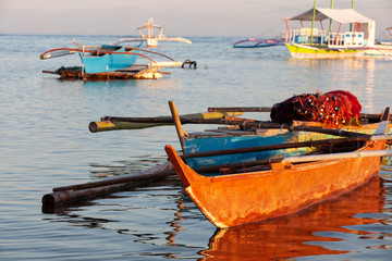 Obraz premium Beautiful amazing nature background. Tropical sea at the sunset light, Bohol Island. Philippines traditional fishing boats.