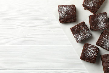 Chocolate cake slices on white wooden background, top view
