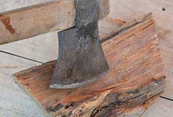 old rusty ax and firewood on background