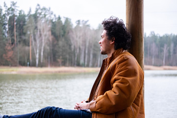 Latin American man looking happy at a lake 