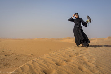 European Tourist posing with peregrine falcon in Dubai desert