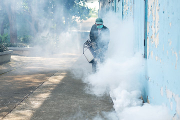 Man work fogging to eliminate mosquito for preventing spread dengue fever
