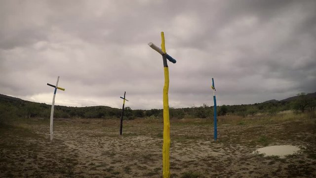 Time-lapse of dark clouds passing over four colorful crosses on Apache holy land