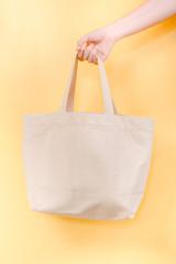 save world and environment activity from beauty hand hold fabric bag for show and use instead of plastic bag with yellow pastel background