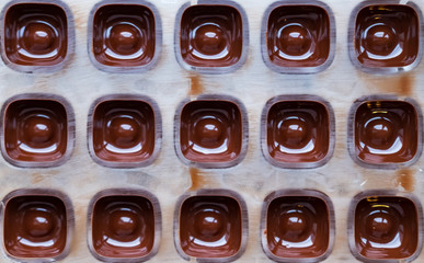 Dark chocolate pralines in mold.
